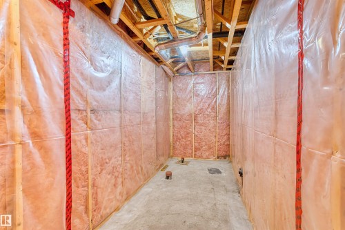Unfinished space featuring wood framing, insulation, vapor barrier, exposed ceiling joists, and a concrete floor - 15504 102 Avenue Nw, Edmonton, AB 