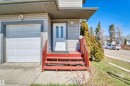 Exterior featuring horizontal siding, attached garage, front entry door with vertical glass inserts, and red-stained wood steps - 15504 102 Avenue Nw, Edmonton, AB 