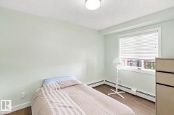 Recessed window with white blinds, wood-finish flooring, and a flush-mount ceiling light - 