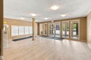 Entrance foyer with wood-finish flooring, flush mount lighting, and large window panels - #413 18126 77 St Nw, Edmonton, AB 