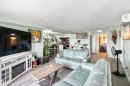 Wood-finish flooring throughout, a built-in electric fireplace, and an open-concept layout - #413 18126 77 St Nw, Edmonton, AB 