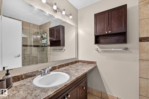 Vanity with an oval undermount sink, chrome faucet, and wood-finish cabinetry - 17919 78 Avenue Nw, Edmonton, AB 