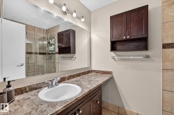 Vanity with an oval undermount sink, chrome faucet, and wood-finish cabinetry - 