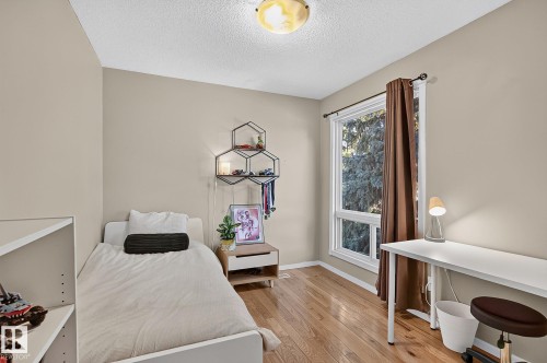 Bright room with wood-finish flooring, a contemporary ceiling light fixture, and a large window - 17919 78 Avenue Nw, Edmonton, AB 