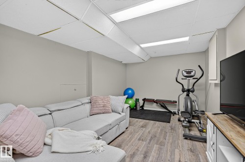 Wood-finish flooring throughout, complemented by light gray wall tones and a white drop ceiling with integrated lighting - 17919 78 Avenue Nw, Edmonton, AB 