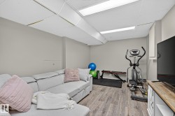 Wood-finish flooring throughout, complemented by light gray wall tones and a white drop ceiling with integrated lighting - 