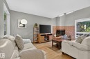 Hardwood flooring, brick fireplace surround, sloped ceiling, recessed lighting, and large windows - 17919 78 Avenue Nw, Edmonton, AB 