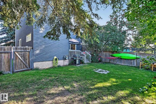 Expansive backyard featuring a manicured lawn, established perimeter fencing, and a multi-level deck with a built-in privacy screen - 17919 78 Avenue Nw, Edmonton, AB 