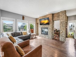 An innovative living room with an elegant and striking double-sided fireplace framed in real stone, for an ultimate flex space. - 