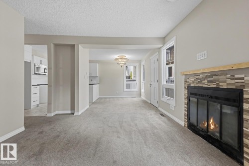 Gas fireplace with a tile surround and wood mantel - 10621 Beaumaris Road Nw, Edmonton, AB 