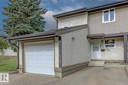 Two-story exterior featuring a single-car garage, stucco and siding finishes, and a covered entryway - 10621 Beaumaris Road Nw, Edmonton, AB 