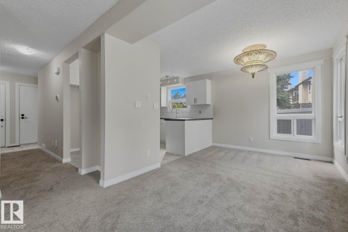 Light gray carpeting, white trim, and a decorative ceiling fixture - 10621 Beaumaris Road Nw, Edmonton, AB 