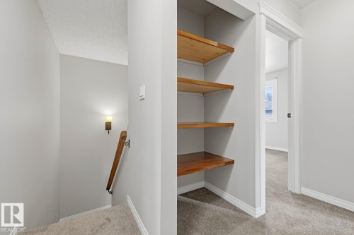 Recessed shelving with wood-finish shelves - 10621 Beaumaris Road Nw, Edmonton, AB 