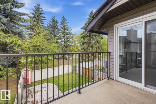 Private balcony with a sliding glass door, black metal railing, and textured flooring - 10621 Beaumaris Road Nw, Edmonton, AB 