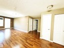 Wood-finish flooring, white paneled doors, and track lighting fixtures - #118 111 Edwards Dr Southwest, Edmonton, AB 