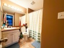 Vanity with integrated sink, overhead vanity lighting, wall-mounted mirror, and tiled flooring - #118 111 Edwards Dr Southwest, Edmonton, AB 