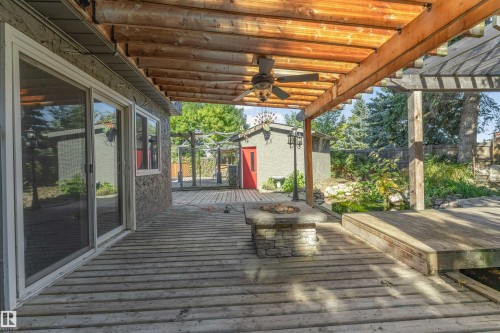 Expansive outdoor decking with a wood pergola, stone fire pit, and ceiling fan - 11208 163A Avenue Nw, Edmonton, AB 