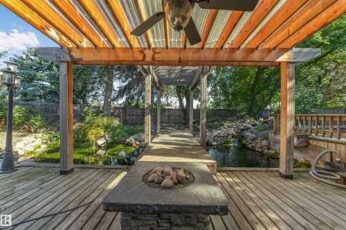 Expansive wooden deck with a covered pergola featuring a ceiling fan - 11208 163A Avenue Nw, Edmonton, AB 