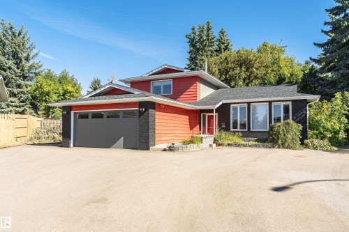 Exterior featuring red siding, dark brick accents, and a large front window array - 11208 163A Avenue Nw, Edmonton, AB 