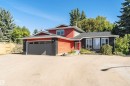 Exterior featuring red siding, dark brick accents, and a large front window array - 11208 163A Avenue Nw, Edmonton, AB 