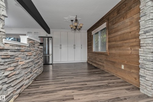 Wood-finish flooring throughout, complemented by a prominent wood-paneled wall - 11208 163A Avenue Nw, Edmonton, AB 