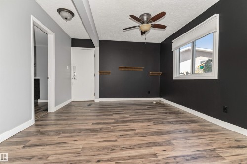 Wood-finish flooring, ceiling fan with light fixture, window with roller shade, built-in shelving, and white trim - 11208 163A Avenue Nw, Edmonton, AB 