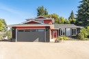 Red-sided exterior with black brick accents, dark gray garage door, and multiple windows - 11208 163A Avenue Nw, Edmonton, AB 
