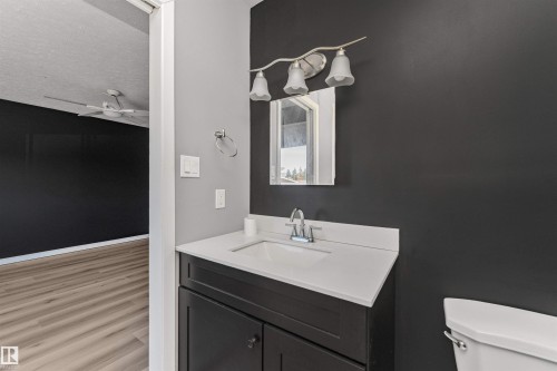 Dark wood-finish vanity with a white solid surface countertop and integrated sink - 11208 163A Avenue Nw, Edmonton, AB 