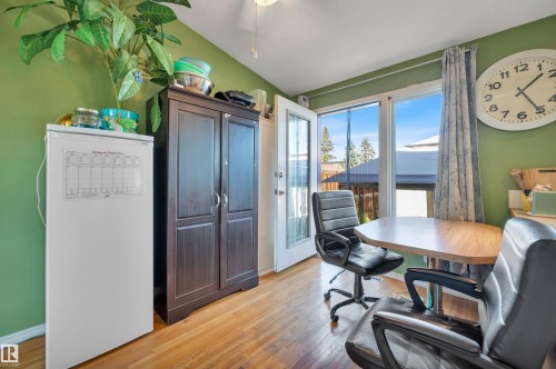 Wood-finish flooring with a side-hinged door, expansive windows, and a built-in storage cabinet - 8812 135A Avenue Nw, Edmonton, AB 