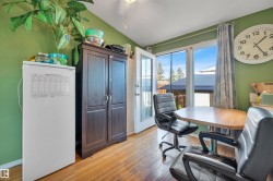 Wood-finish flooring with a side-hinged door, expansive windows, and a built-in storage cabinet - 