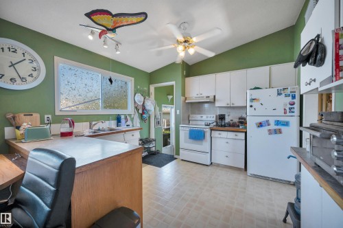 Kitchen featuring white cabinetry, vaulted ceiling, and ample natural light - 8812 135A Avenue Nw, Edmonton, AB 