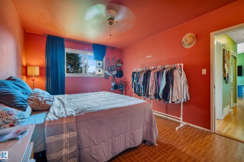 Window with exterior views, wood-finish flooring, ceiling fan, and painted walls - 8812 135A Avenue Nw, Edmonton, AB 