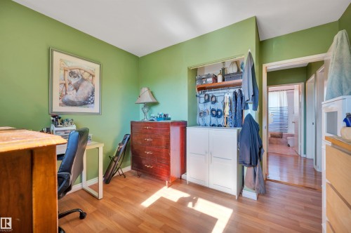 Wood-finish flooring with a built-in closet featuring an upper shelf and hanging rod - 8812 135A Avenue Nw, Edmonton, AB 
