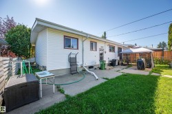 Fenced backyard featuring a concrete patio, a detached gazebo, and a grass lawn - 