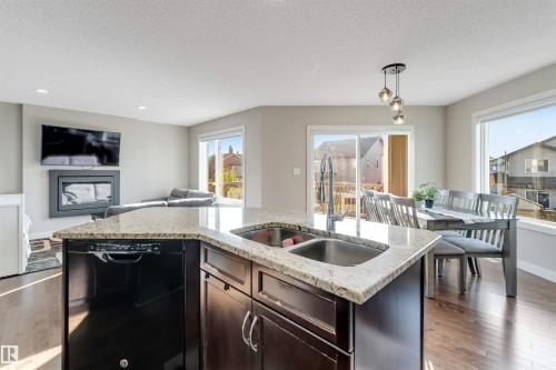 Kitchen island with granite countertop and double stainless steel sink - 136 55 Street Sw, Edmonton, AB 