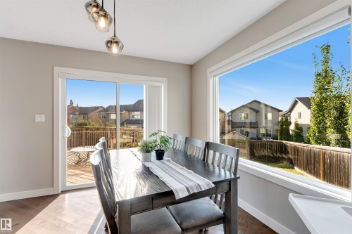 Wood-finish flooring, sliding glass door, large picture window, and pendant lighting - 136 55 Street Sw, Edmonton, AB 