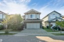 Two-story residence featuring a two-car garage, stone and siding exterior, and a concrete driveway - 136 55 Street Sw, Edmonton, AB 