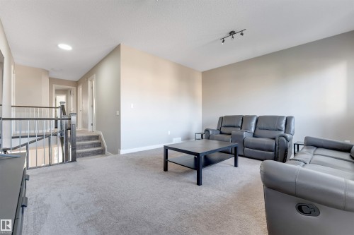 Carpeted living area with neutral wall tones and track lighting - 136 55 Street Sw, Edmonton, AB 