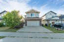 Two-story property featuring light gray siding, dark gray stone detailing, and an attached two-car garage - 136 55 Street Sw, Edmonton, AB 