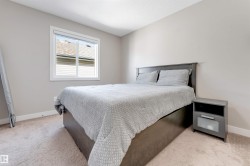Neutral paint palette, carpeted flooring, window with white trim, and a built-in nightstand - 