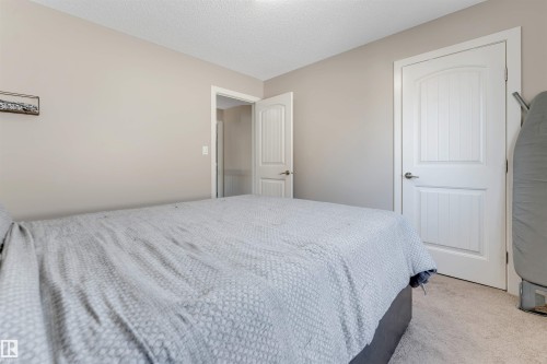 Textured carpet flooring, neutral wall paint, and white paneled doors - 136 55 Street Sw, Edmonton, AB 