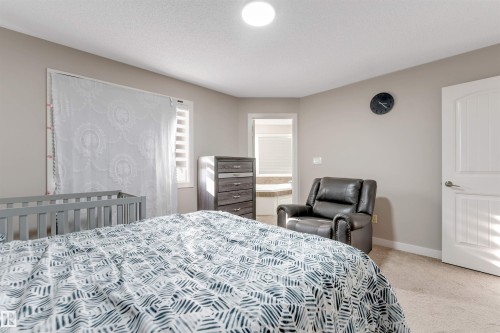 Carpeted flooring, neutral wall tones, and a window with horizontal blinds - 136 55 Street Sw, Edmonton, AB 