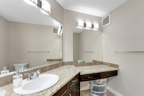 Bathroom vanity with a white oval sink, chrome faucet, and integrated countertop - 136 55 Street Sw, Edmonton, AB 