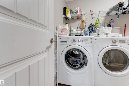 Laundry space featuring a front-loading washing machine, a front-loading dryer, and wall-mounted wire shelving - 136 55 Street Sw, Edmonton, AB 