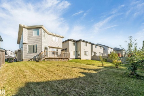 Expansive rear yard with a wooden deck, mature trees, and landscaping - 136 55 Street Sw, Edmonton, AB 