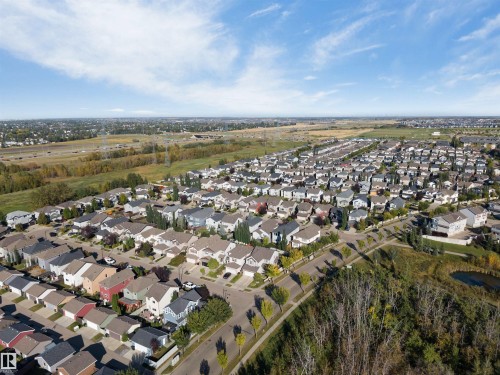 Residential neighborhood with varied architectural styles, mature trees, paved streets, and a pond feature - 136 55 Street Sw, Edmonton, AB 
