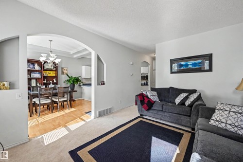 Archway entry, recessed wall niches, light wood-finish flooring, built-in shelving, tray ceiling with chandelier - 8513 156 Avenue Nw, Edmonton, AB 
