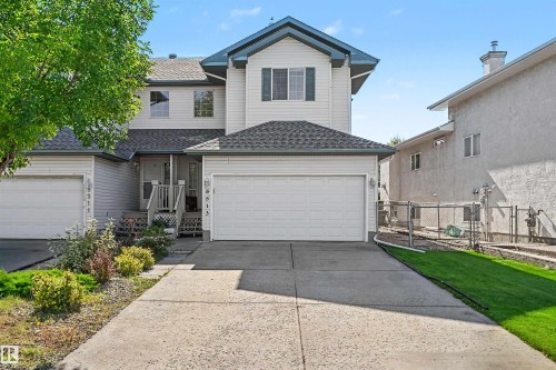 Siding exterior with shuttered windows, attached garage, and a concrete driveway - 8513 156 Avenue Nw, Edmonton, AB 