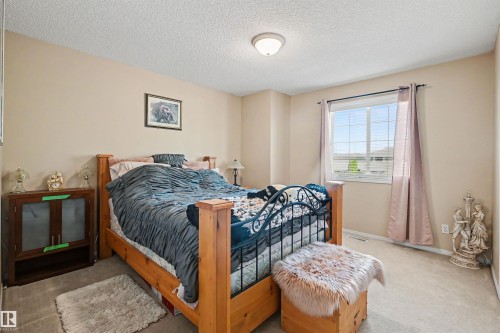 Neutral-toned wall paint, textured ceiling, flush-mount ceiling light fixture, and a window with horizontal blinds - 8513 156 Avenue Nw, Edmonton, AB 