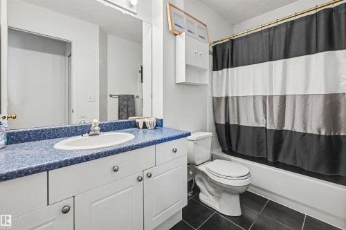 Full vanity with a blue flecked countertop and integrated sink - 8513 156 Avenue Nw, Edmonton, AB 